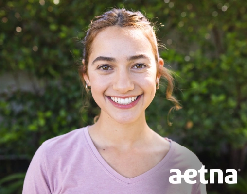 A smiling woman representing patients with accepted Aetna dental insurance coverage
