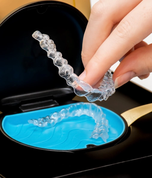 Clear Invisalign aligners being placed into a protective case.
